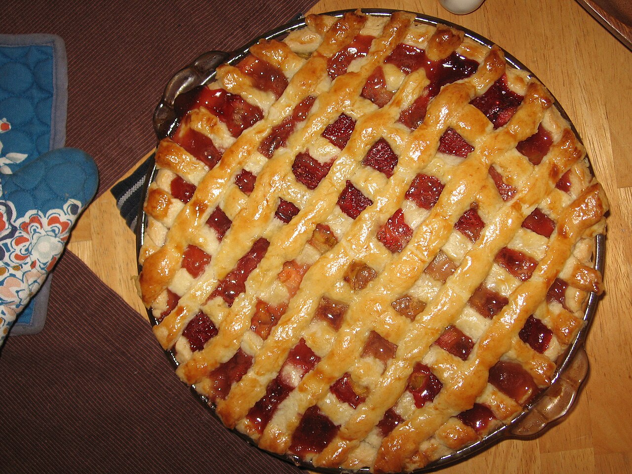 A golden, hand-rolled strawberry-rhubarb pie, bubbling at the edges.